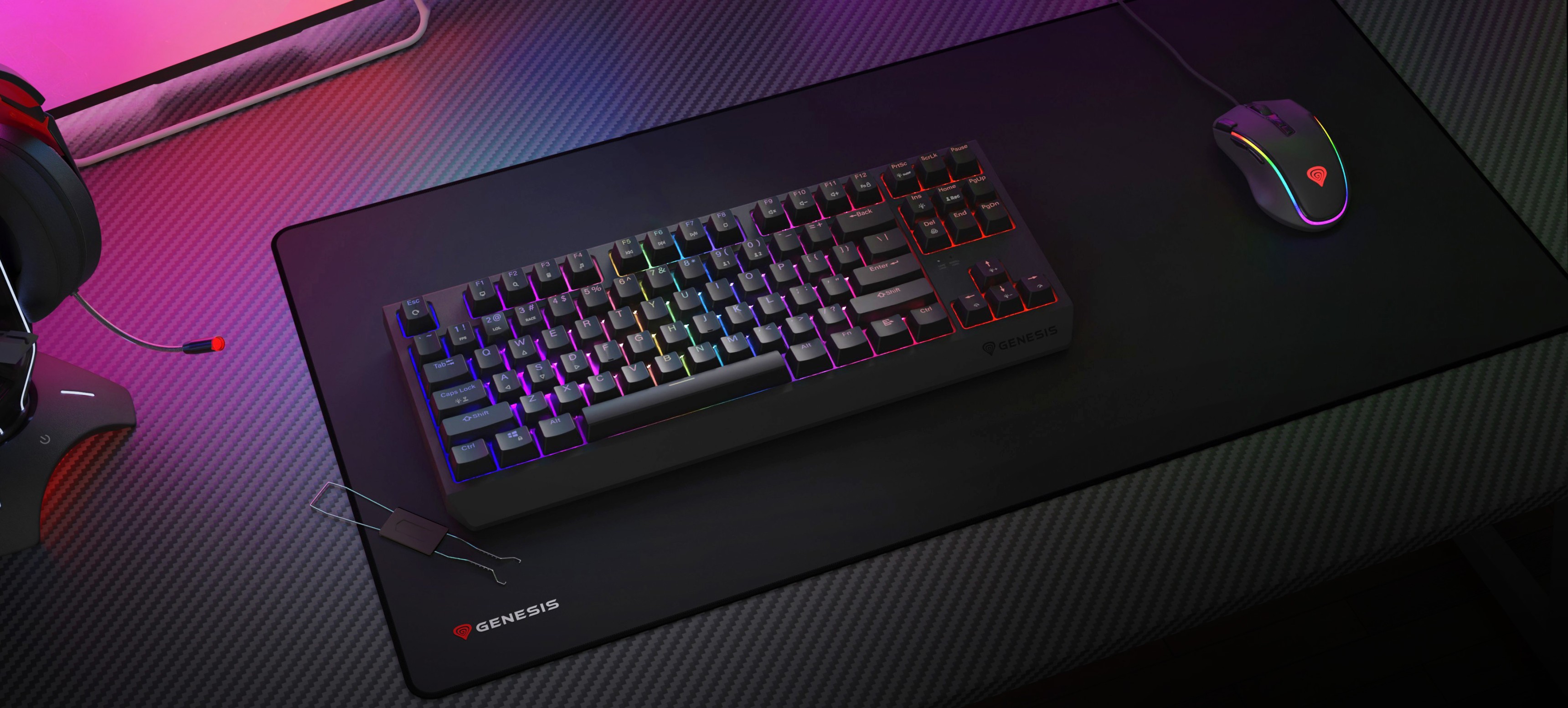 Бездротова механічна ігрова клавіатура з RGB-підсвічуванням, розташована на великому килимку для миші поруч з ігровою мишею та гарнітурою